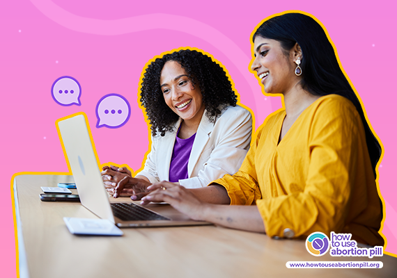 Two women smiling while collaborating on a laptop, representing supportive abortion counselling and provider communication